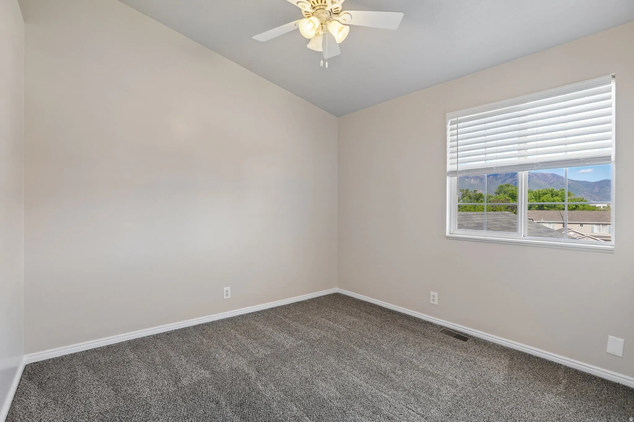 Room featuring vaulted ceilings, neutral wall tones, and gray carpet flooring