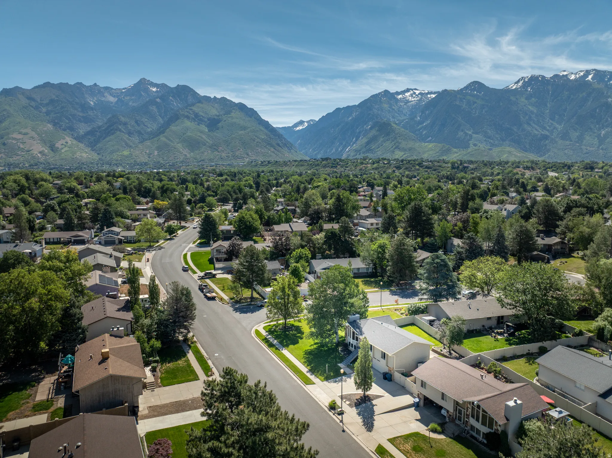 Residential neighborhood featuring mature trees and mountain scenery
