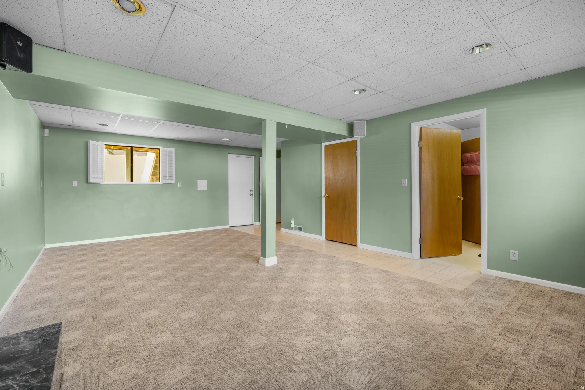 Spacious room featuring patterned carpet flooring and light green walls