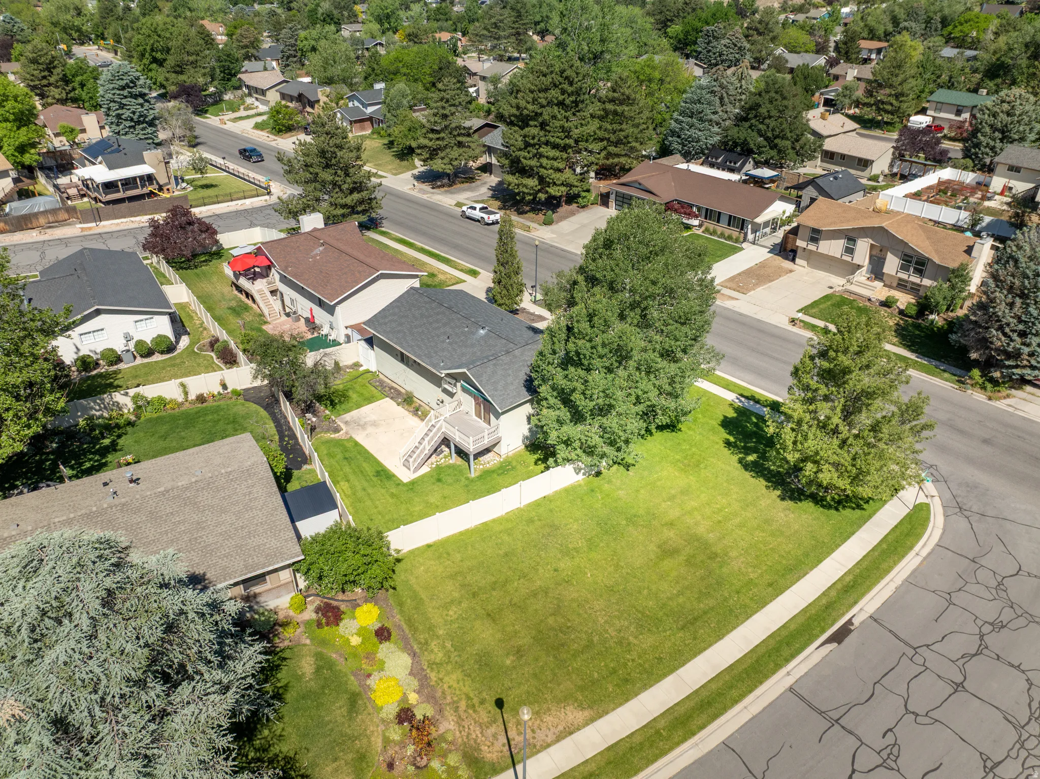 Large corner lot featuring a spacious green lawn and mature trees