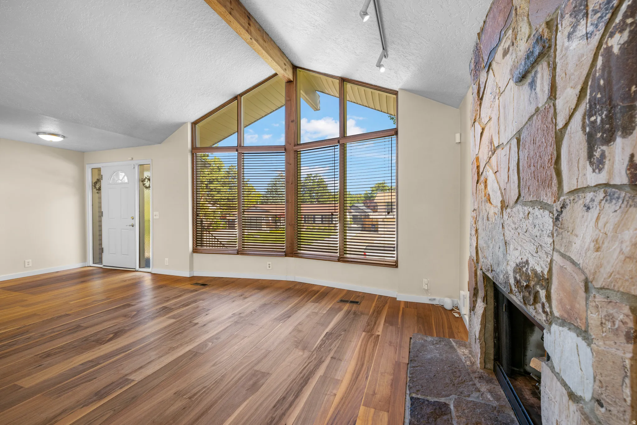 Wood-finish flooring throughout, complemented by a prominent stone fireplace