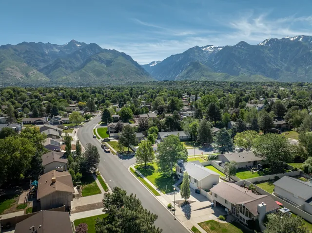 Residential neighborhood featuring mature trees and mountain scenery