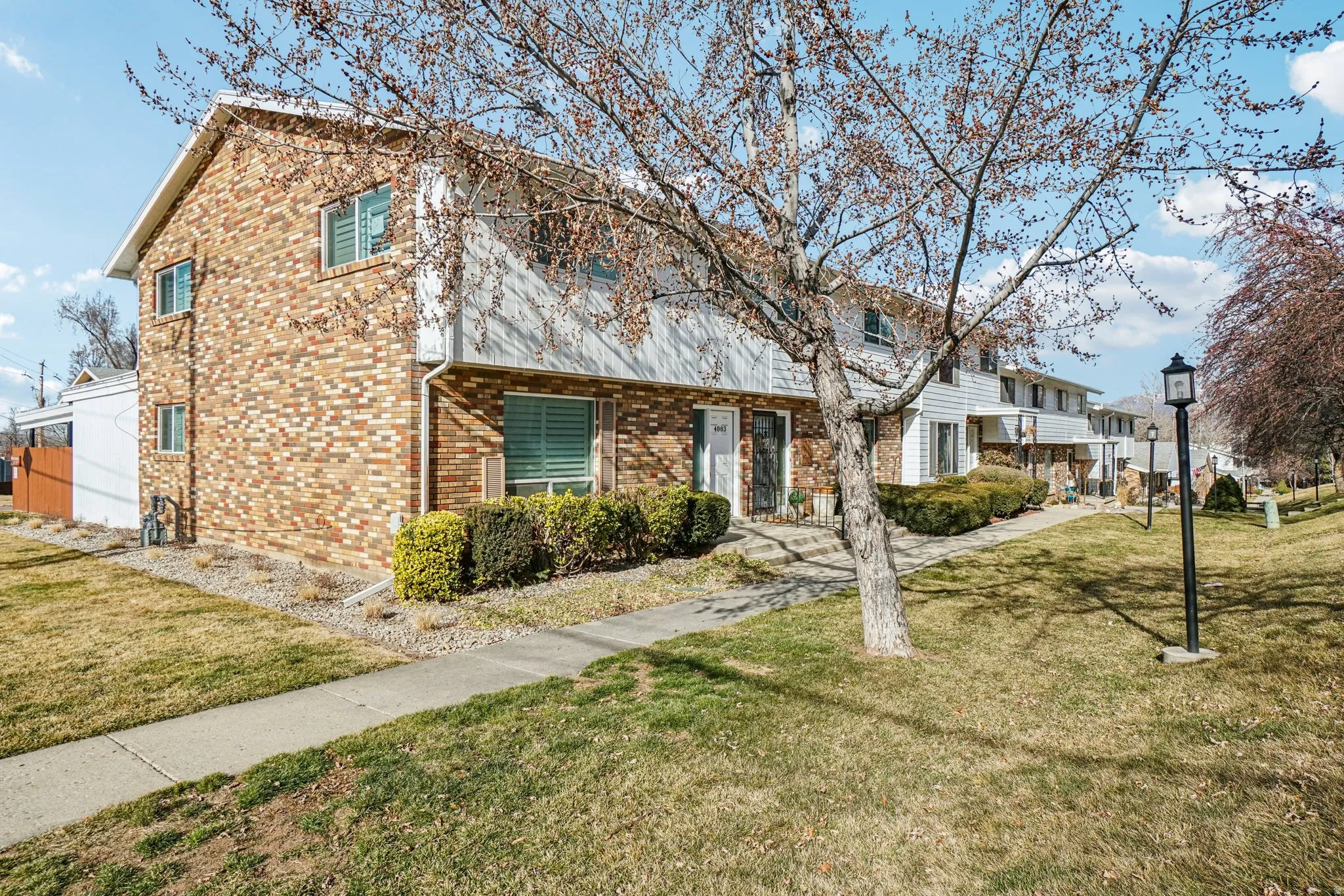 Brick and siding exterior featuring multiple windows and a covered entry