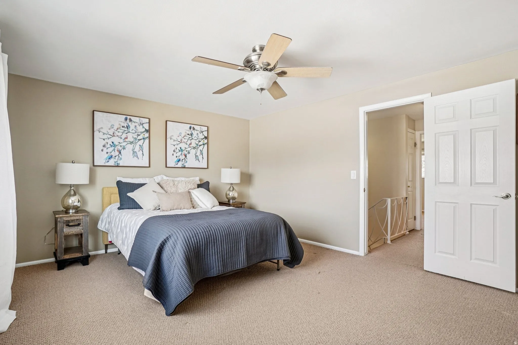 Carpeted room with neutral-toned walls, featuring a ceiling fan with light fixture