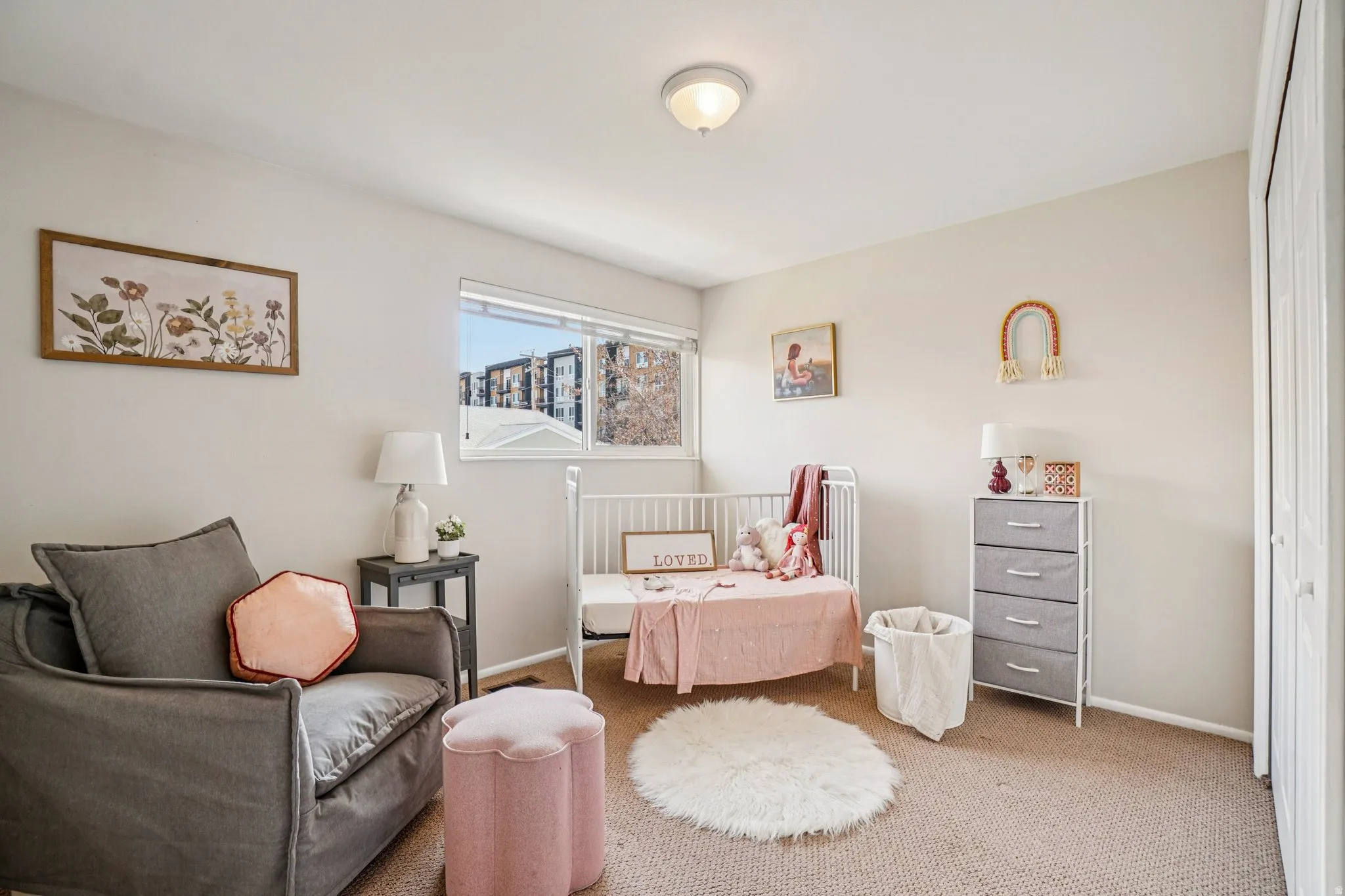 Carpeted room featuring a ceiling-mounted light fixture, a window with exterior views, and a bi-fold closet door