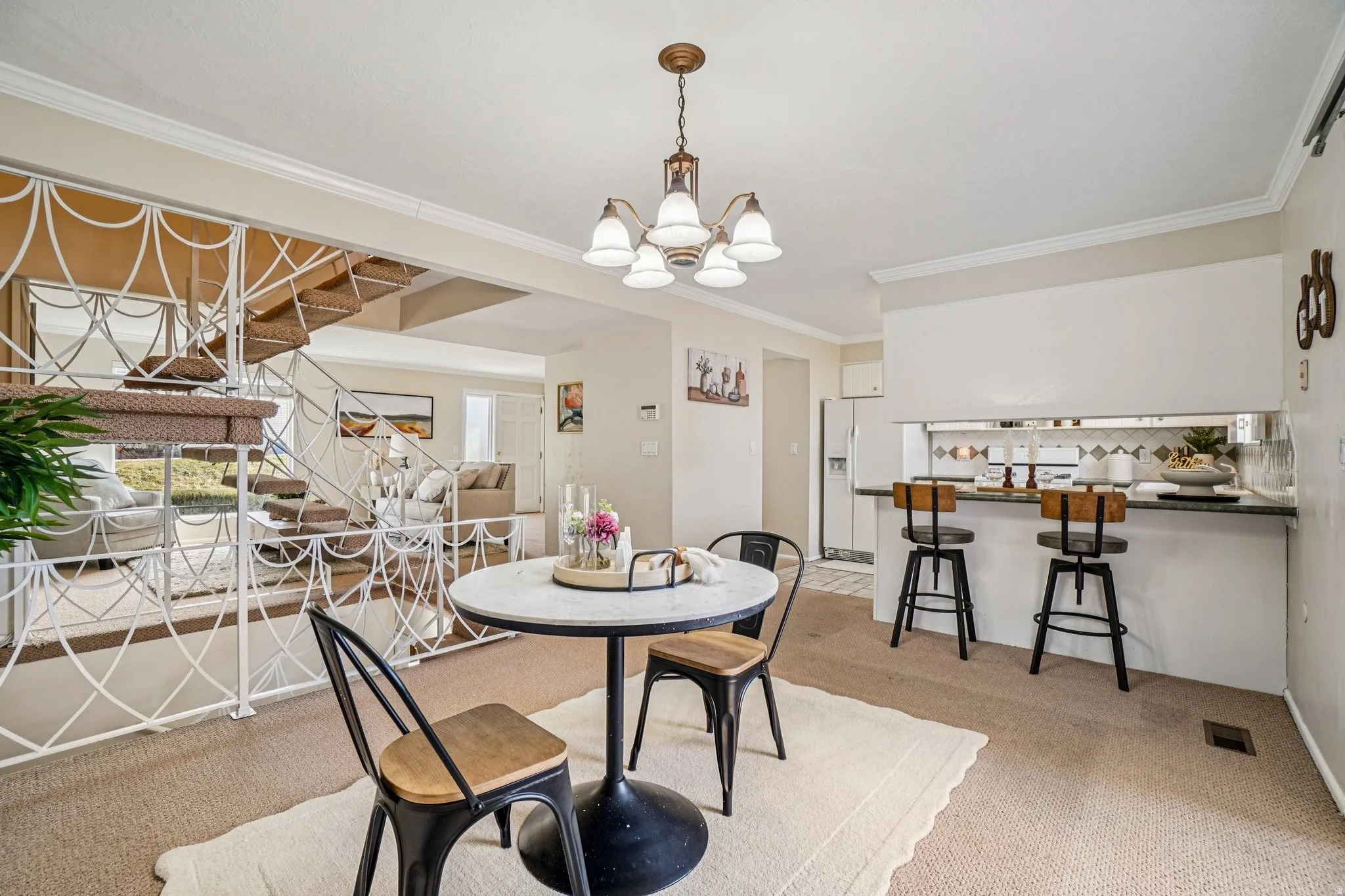 Dining area with textured carpeting and a central chandelier
