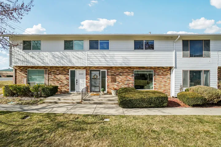 Brick and siding exterior featuring multiple windows with blinds