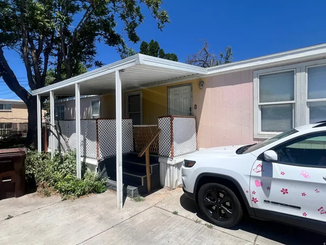Exterior featuring a covered porch, white lattice fencing, and a side entry door