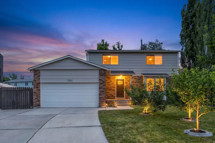 Two-story residence featuring a brick and siding exterior, concrete driveway, and attached garage