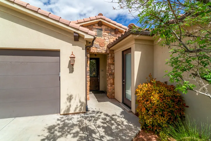 Exterior entry featuring a tile roof, stucco siding, and stone accents