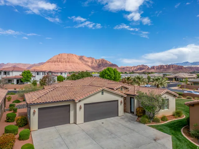 Southwestern-style residence featuring a stucco exterior, tile roof, and an attached two-car garage