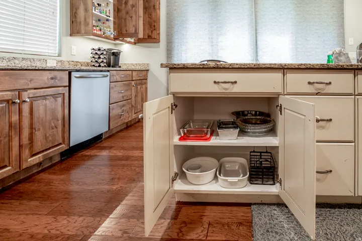 Kitchen featuring wood-finish flooring, granite countertops, and two-tone cabinetry with light-colored lower cabinets and darker wood upper cabinets