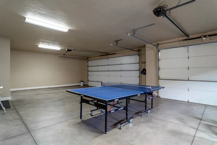Spacious garage featuring concrete flooring and two overhead doors with automatic openers