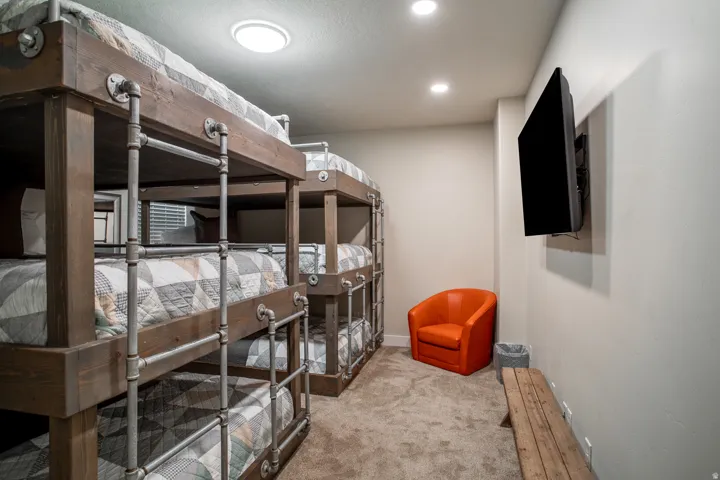 Custom built-in bunk beds with wood-finish frames and industrial-style pipe railings