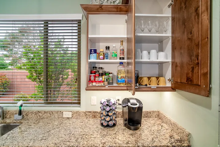 Kitchen countertop featuring a stainless steel sink, light-toned granite-finish countertop, and under-cabinet lighting