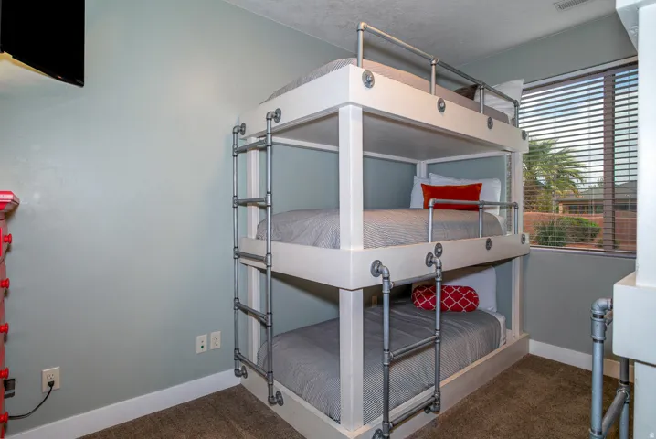 Custom built-in triple bunk beds with industrial-style pipe railings and ladders