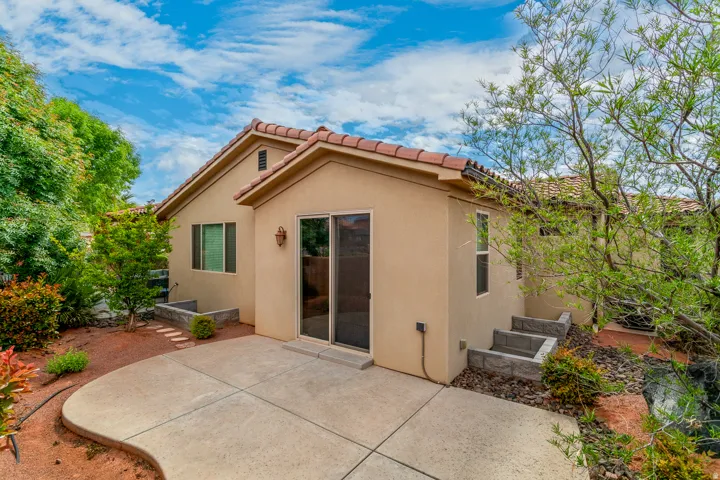Exterior patio featuring a concrete surface, sliding glass door entry, stucco siding, and a red tile roof