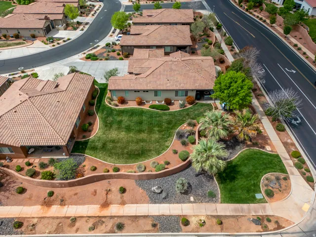 Exterior property featuring a terracotta tile roof, stucco finish, and a large manicured lawn