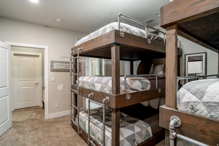 Built-in triple bunk beds crafted from dark wood and industrial-style piping
