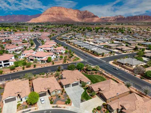 Expansive residential neighborhood featuring single-family homes with tile roofs, desert landscaping, and paved roads