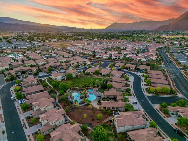 Expansive aerial showcasing a residential community with abundant housing, a large central swimming pool, and dedicated greenspace