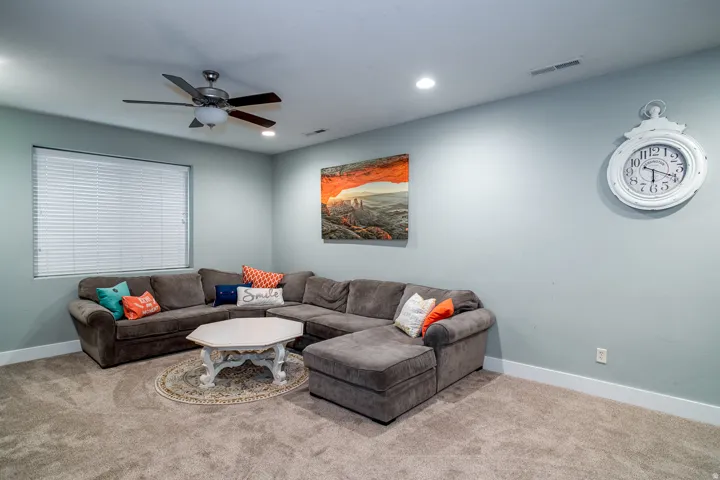 Carpeted interior space featuring a window with horizontal blinds, recessed lighting, and a ceiling fan