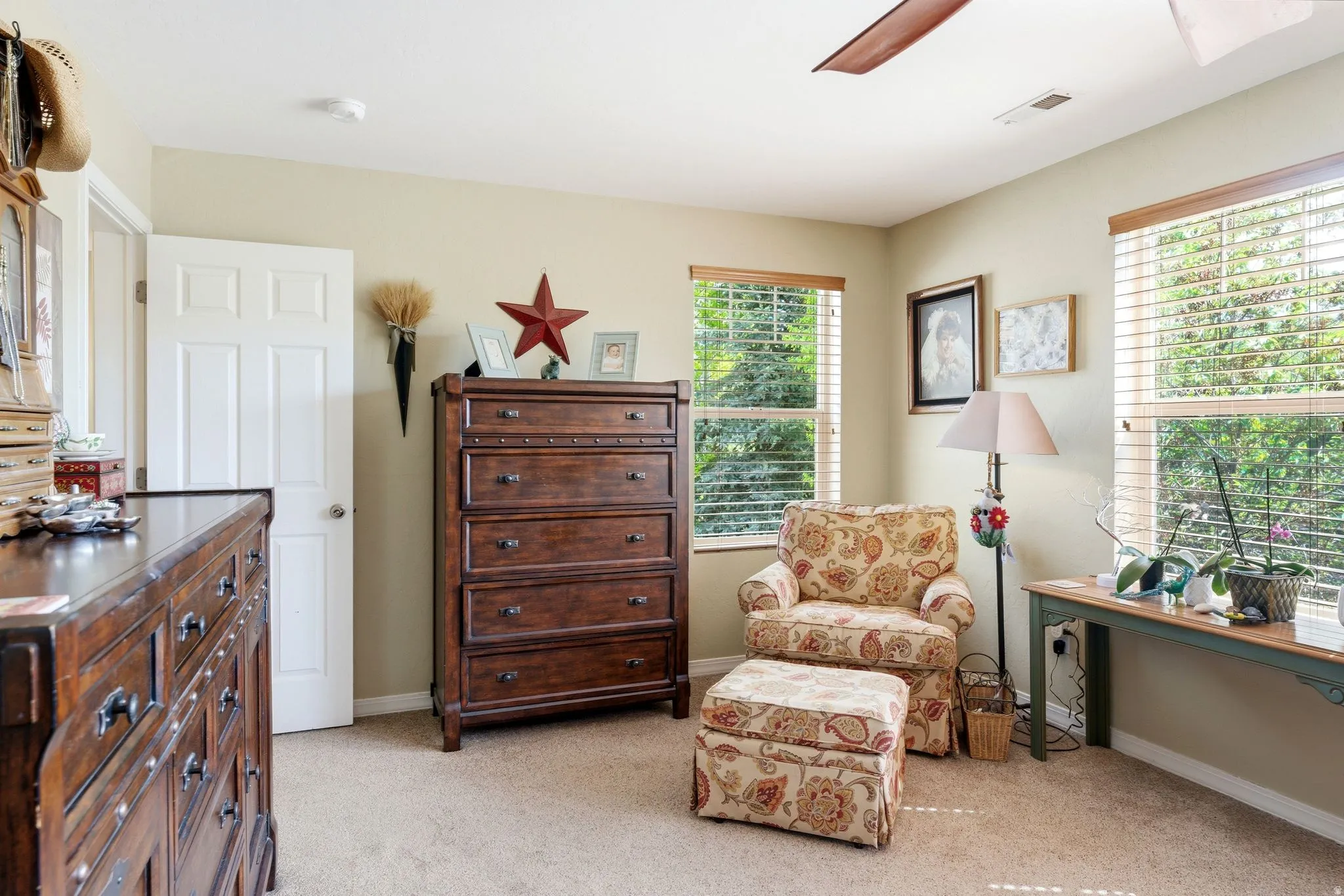 Textured carpet flooring, neutral painted walls, white trim, and multiple windows with blinds