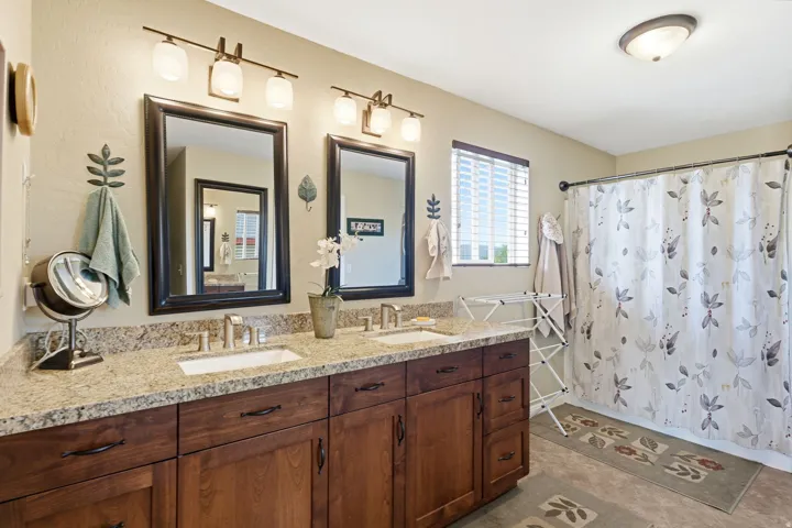 Double vanity featuring granite countertops and undermount sinks