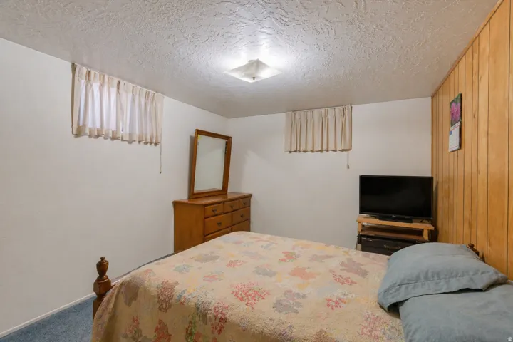 Room featuring light-colored walls and a wood-paneled accent wall