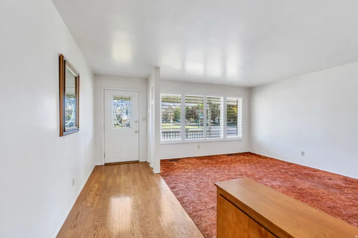 Entryway with wood-finish flooring extending to a front door featuring decorative glass