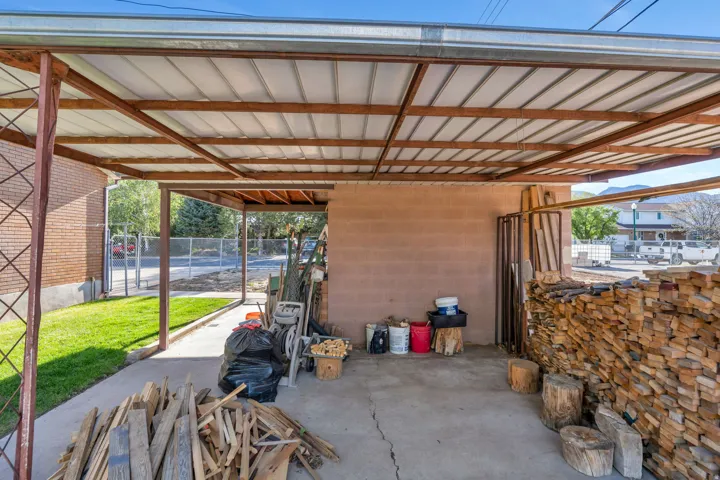 Expansive covered carport featuring a concrete slab, metal frame, and corrugated roof