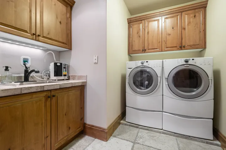 Spacious laundry room with sink and plenty of storage