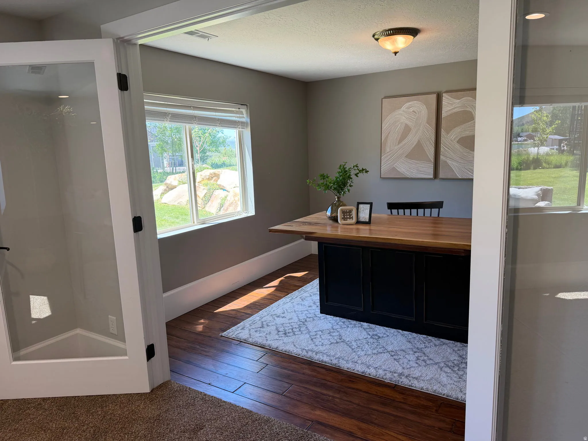 Room with wood-finish flooring, a window offering natural light, and a ceiling-mounted light fixture