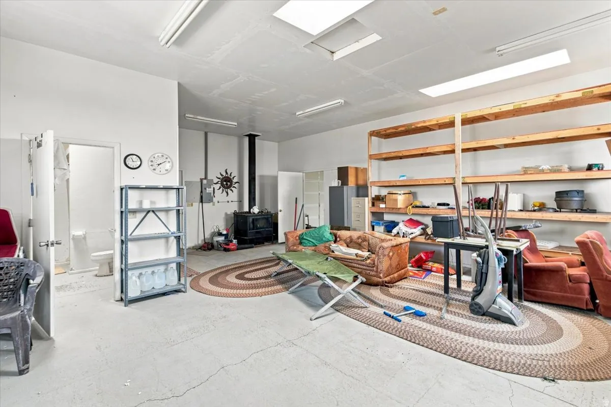 Concrete flooring with exposed ceiling beams and recessed lighting