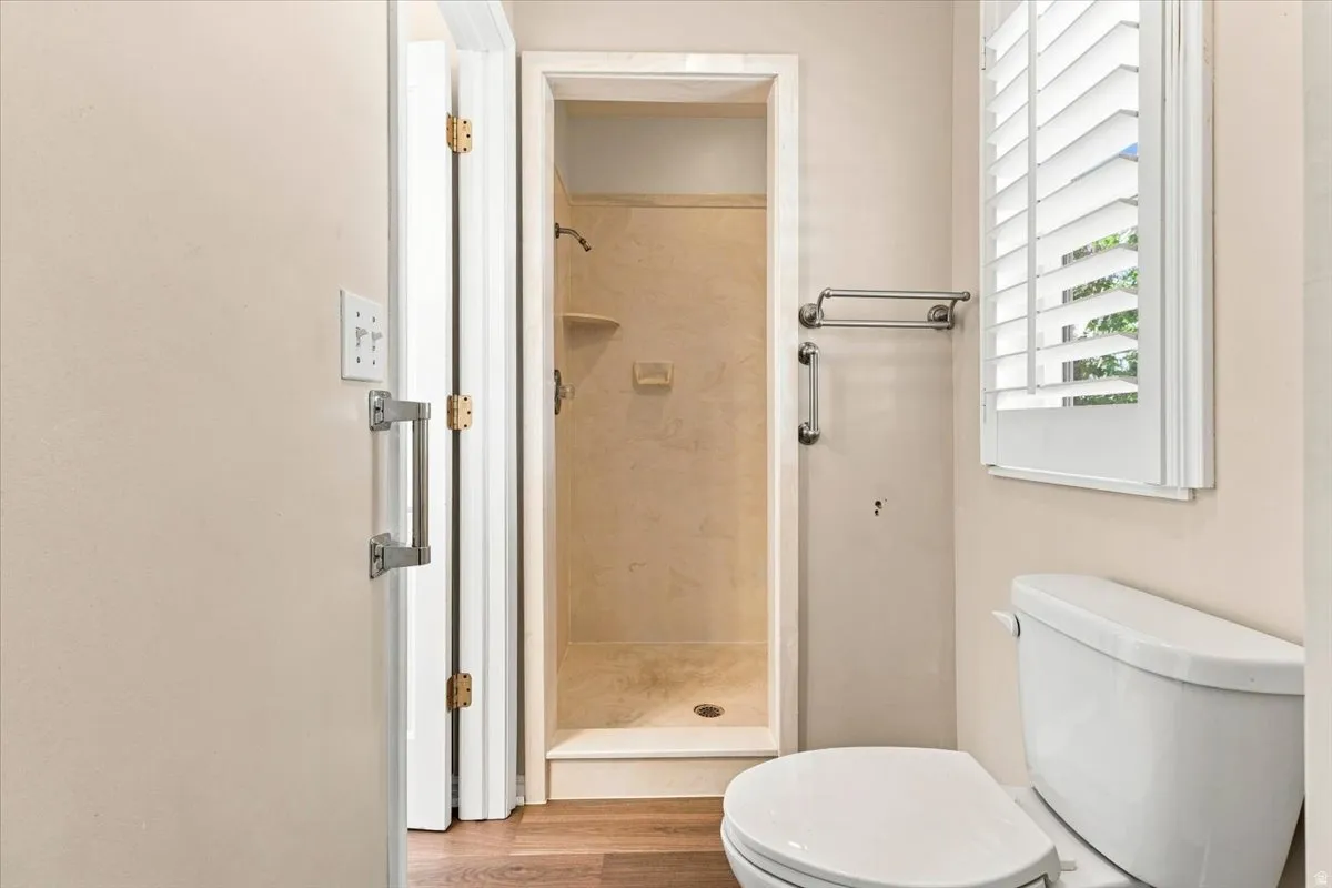 Shower with tiled walls and flooring, a built-in shelf, and a showerhead