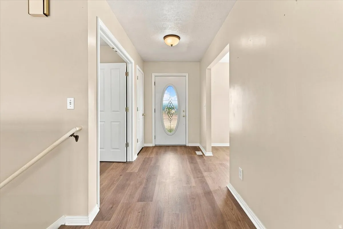 Entryway featuring wood-finish flooring, a decorative glass front door, and archways