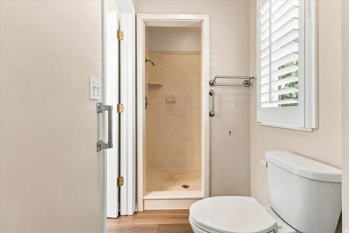 Shower with tiled walls and flooring, a built-in shelf, and a showerhead