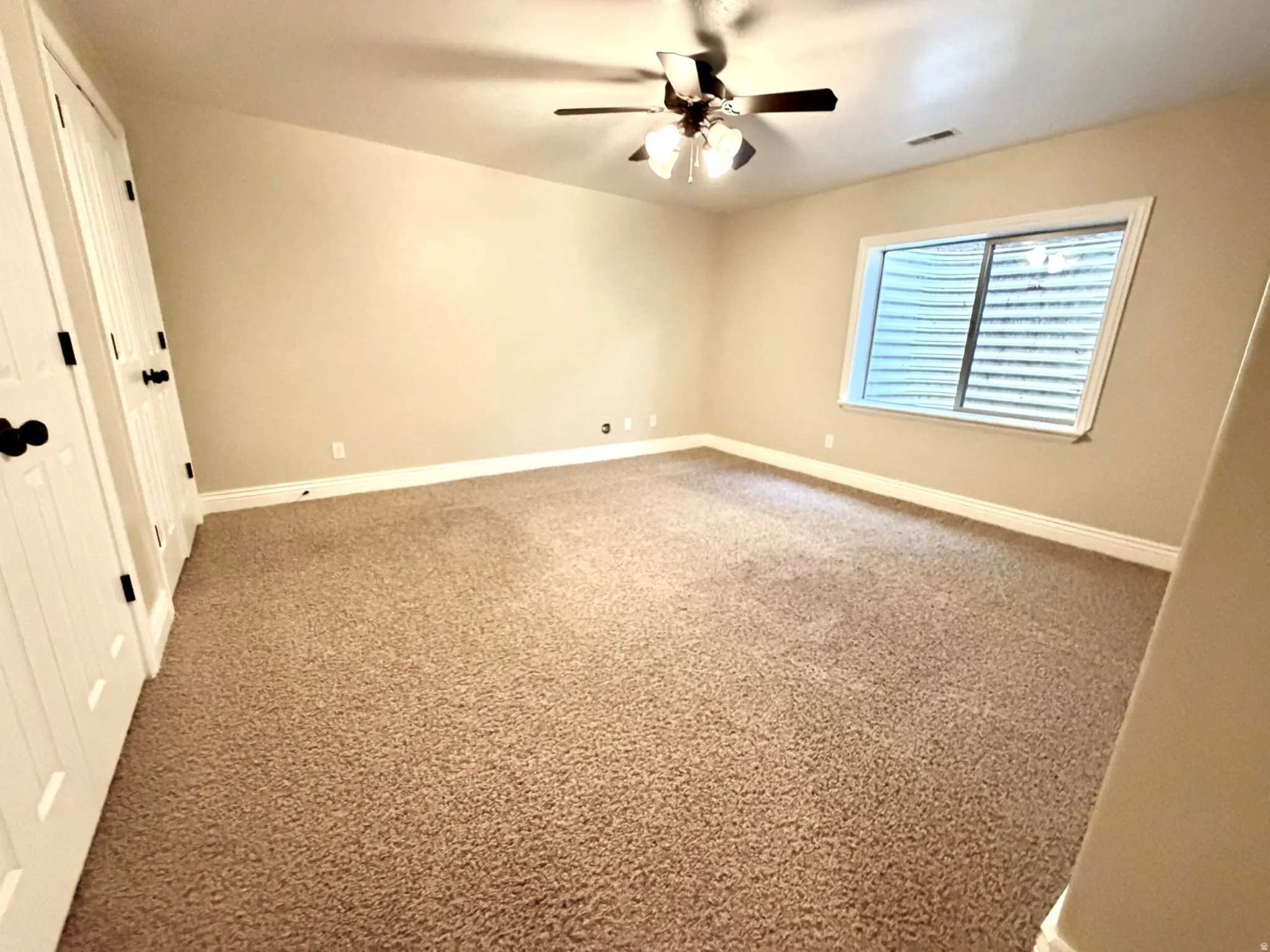 Bedroom 1. Spacious room featuring textured carpeting, neutral wall finishes, and white baseboards
