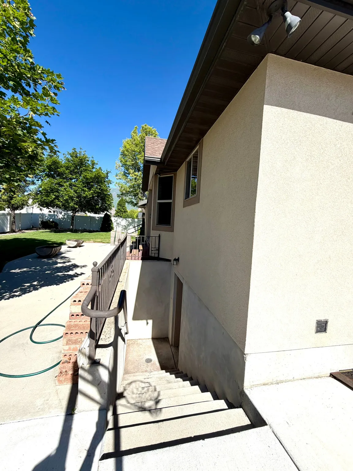 Exterior outside staircase into basement.  Stucco finish with a contrasting dark fascia and soffit