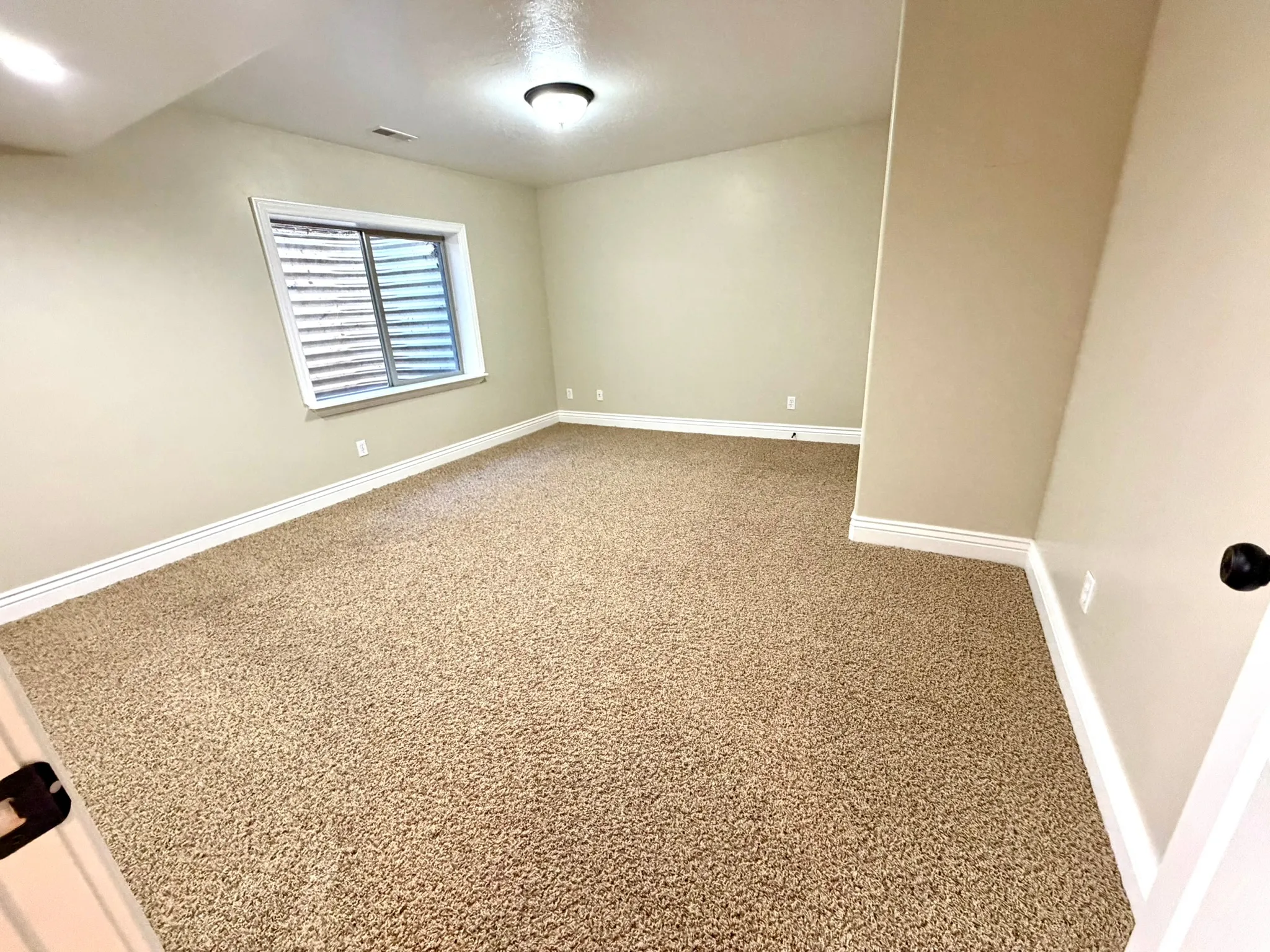 Bedroom 2. Spacious room featuring neutral carpeting and light-toned walls