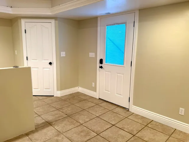 Outside entrance from back yard with tile flooring extending throughout the space
