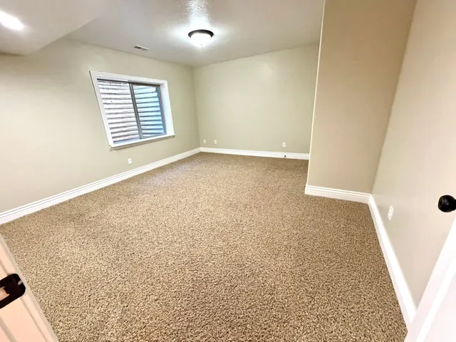 Bedroom 2. Spacious room featuring neutral carpeting and light-toned walls