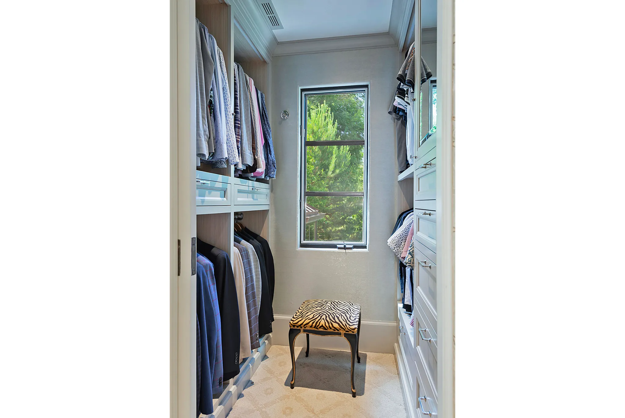 Custom closet system featuring built-in cabinetry, multiple hanging rods, and integrated drawers with polished hardware