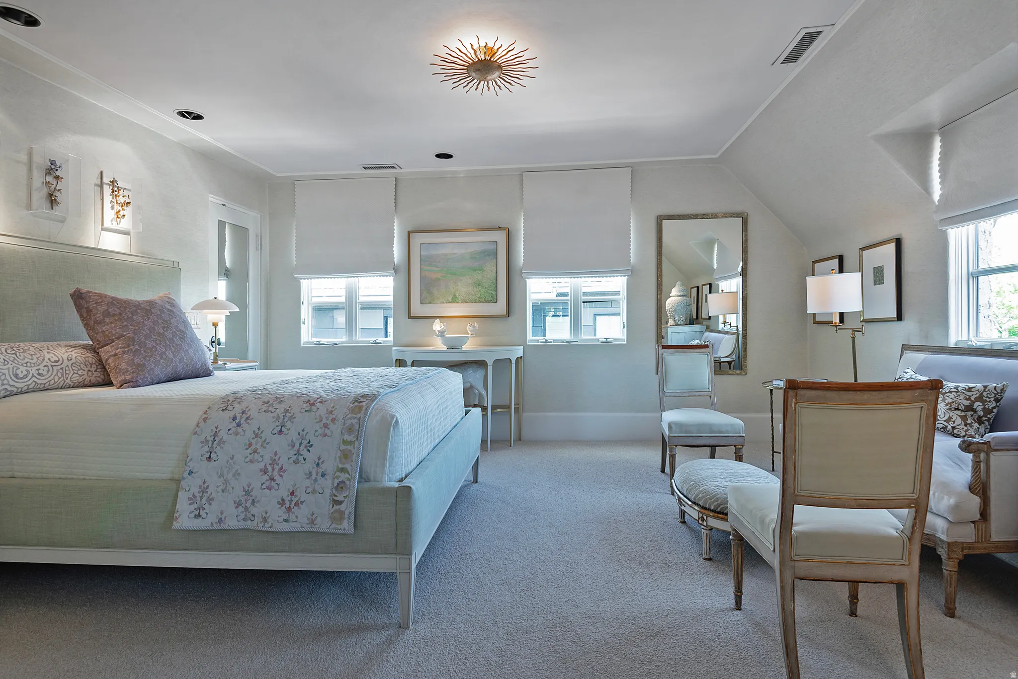 Spacious room featuring sloped ceilings, recessed lighting, and a distinctive ceiling fixture