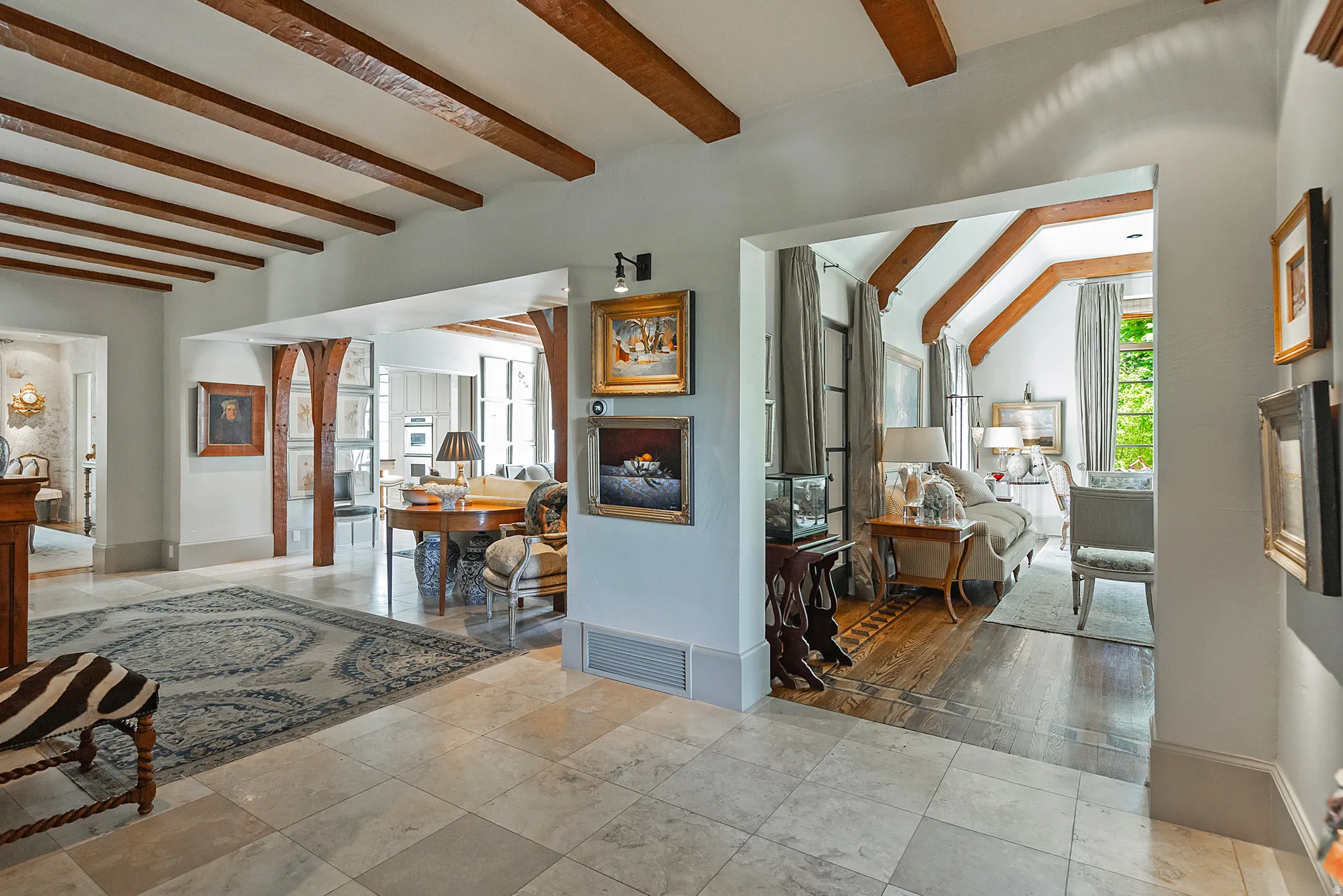 Interior space featuring exposed wood ceiling beams and light-toned tile flooring
