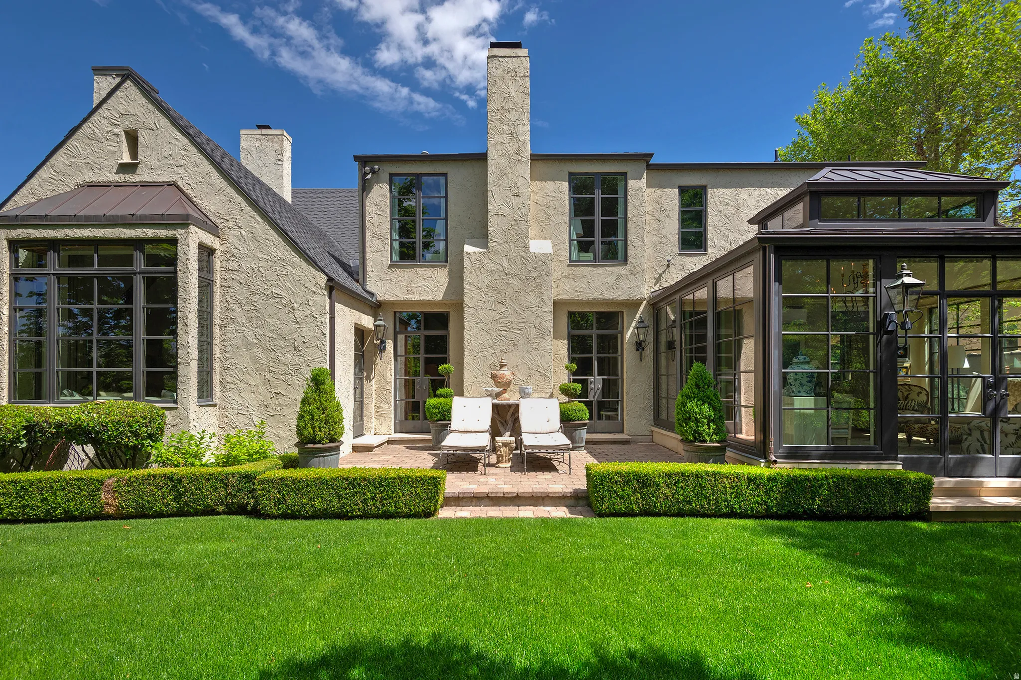 Stucco exterior with a multi-pane window bay and a metal roof accent