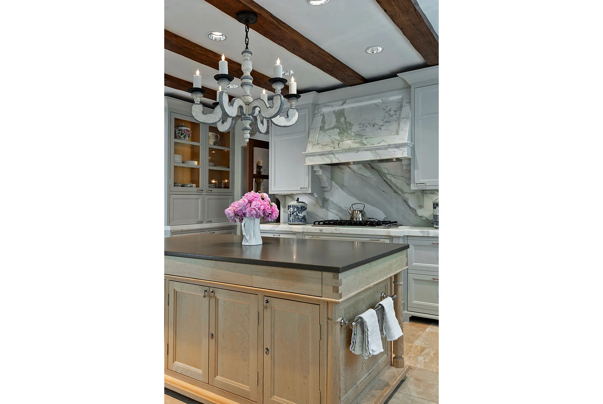 Kitchen island with a dark countertop and light wood-finish cabinetry