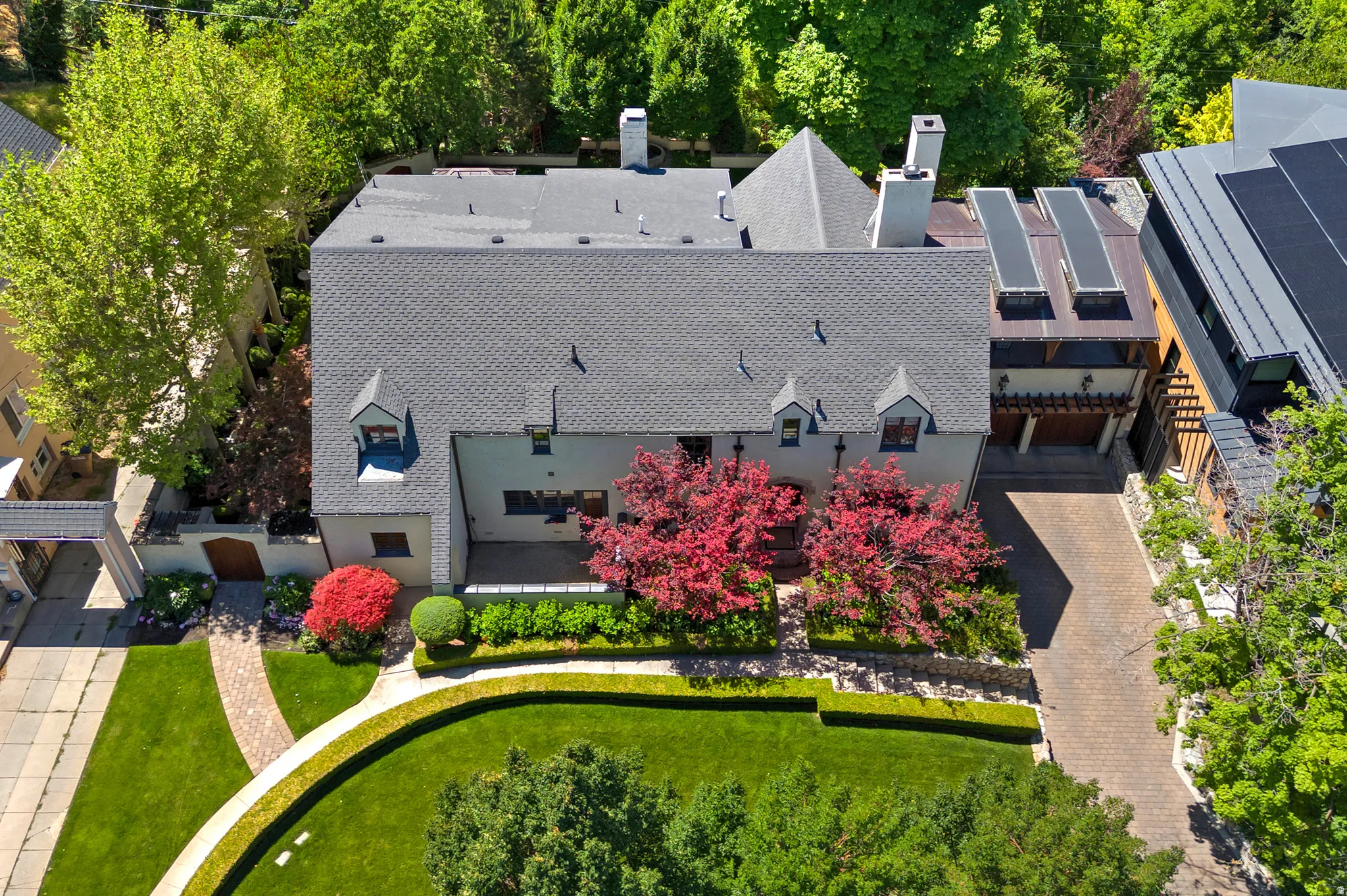 Expansive estate featuring a large main residence with a gray shingle roof and multiple dormer windows