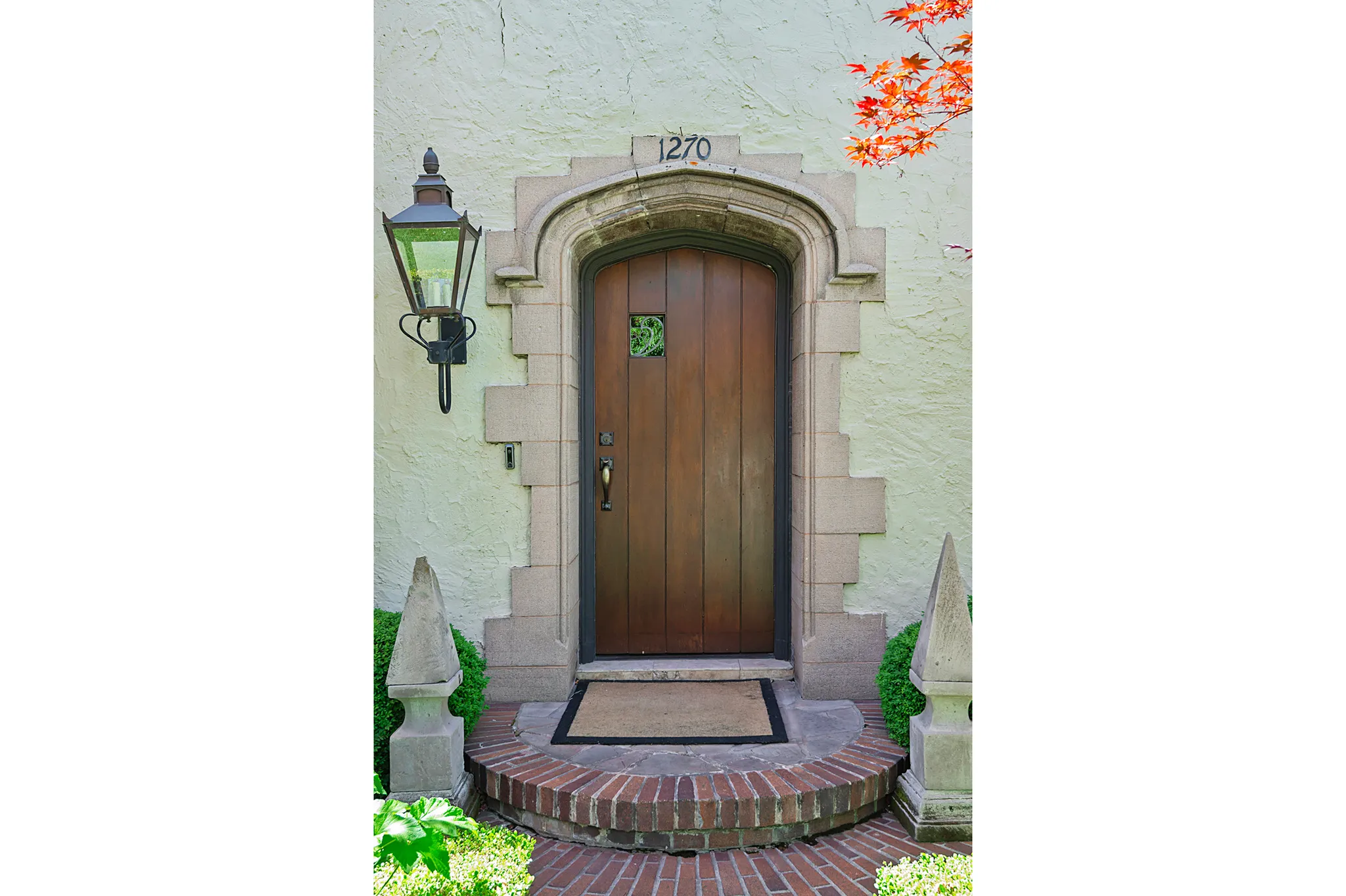 Arched wooden entry door with decorative stone surround