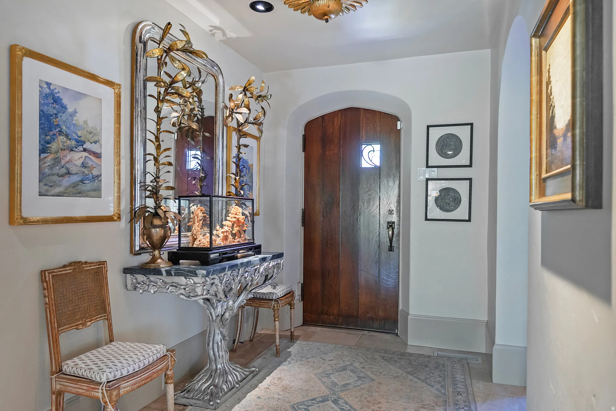 Arched wooden door with decorative glass inlay, complemented by a stone-look flooring with patterned inlay